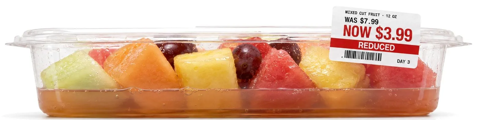 Conventional tray of cut fruit sitting in pooled juice with a markdown label — was $7.99, now $3.99